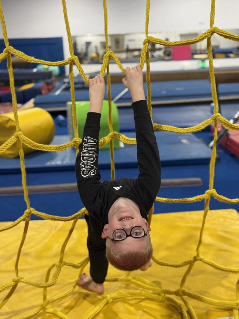 Child climbing up rope net